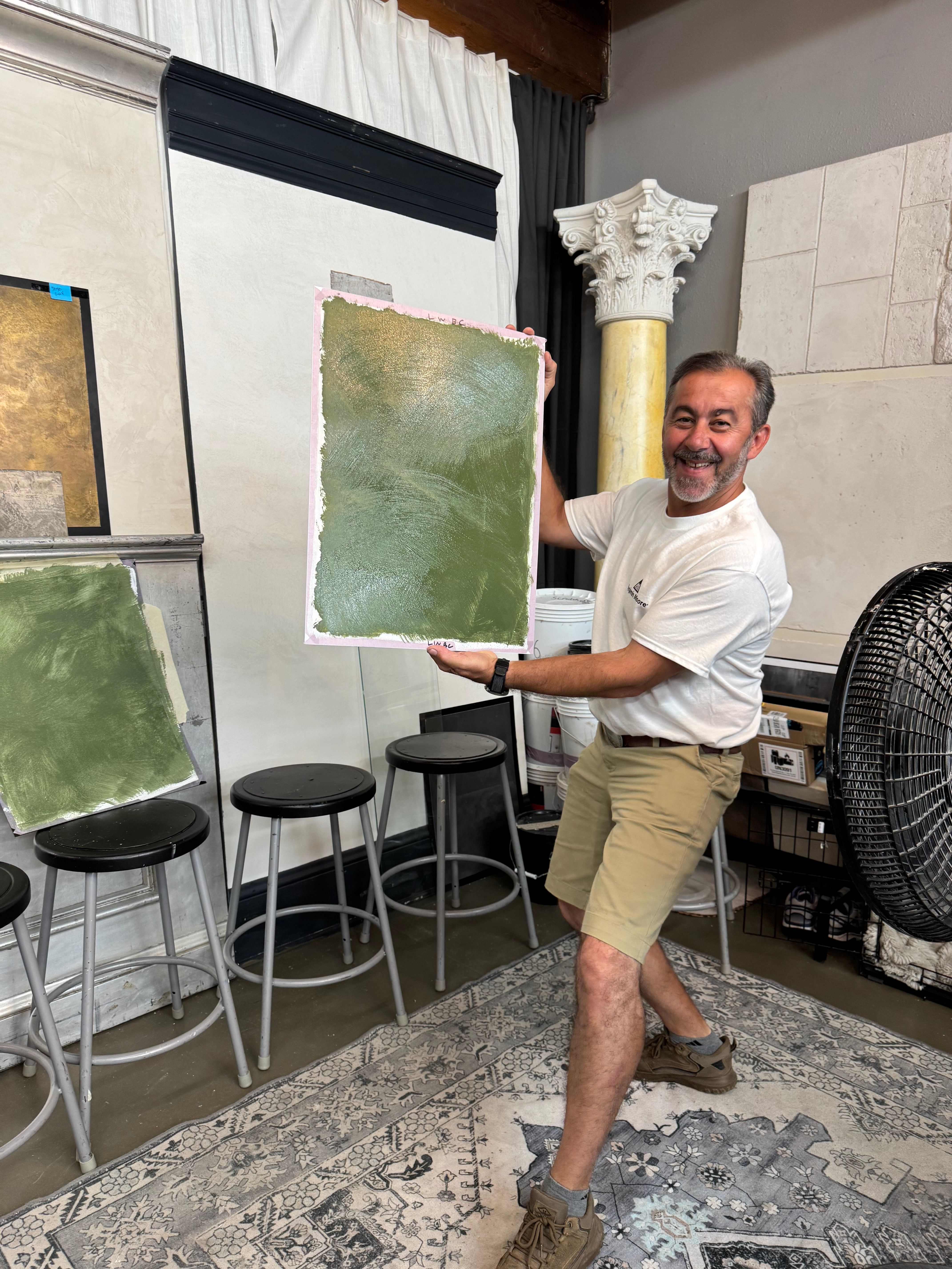 Instructor proudly displaying completed plaster sample showcasing workshop results